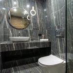 Luxurious bathroom interior featuring sleek marble walls, floating sink, and a contemporary toilet design.